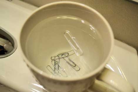 How do you make a paper clip float on water?